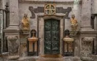 Puerta Santa con dos figuras policromadas, dos pilas de agua benditay una de las cruces de consagración 