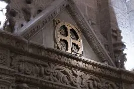 Detalle de una cruz de consagración de 1211 rodeada por elementos decorativos  del XVI