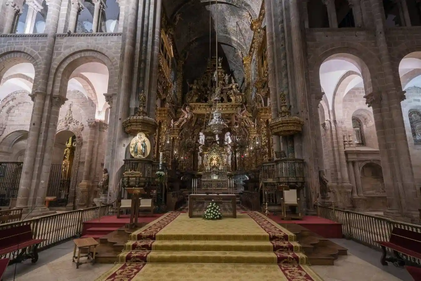 La capilla mayor barroca contrasta, sin desentonar,  con los muros y arcos románicos
