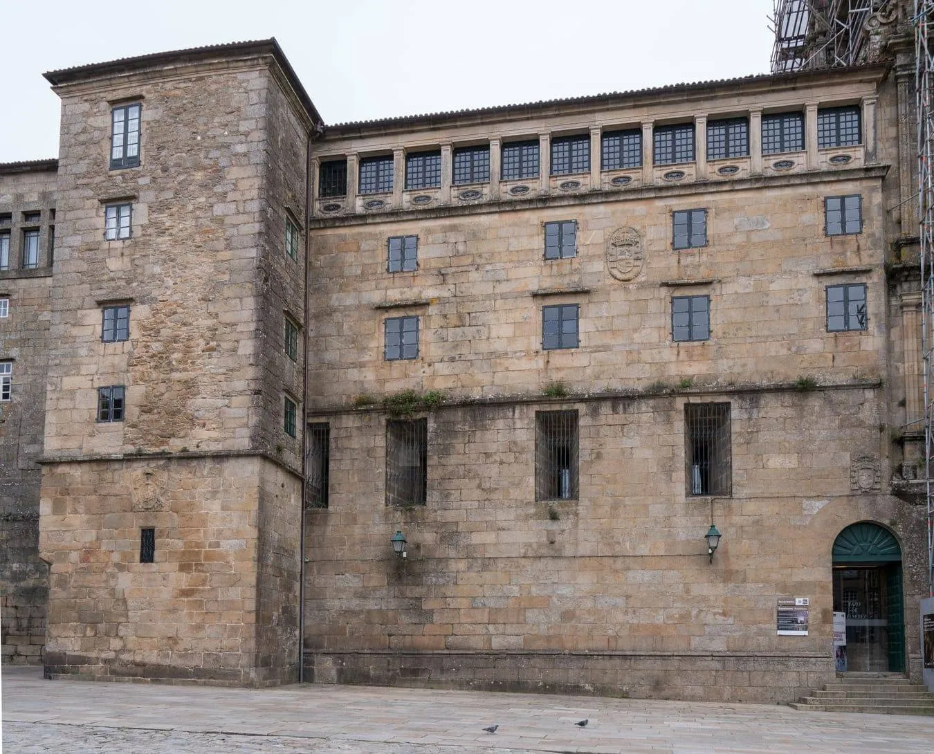 Vista de la fachada actual del Palacio de Gelmírez en la plaza del Obradoiro. A la derecha, el acceso al Palacio.