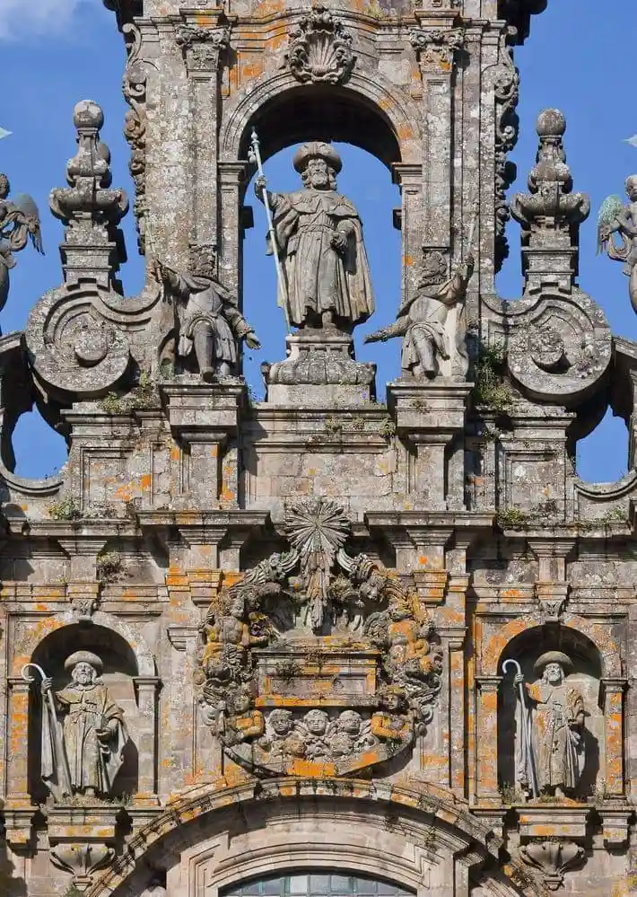 Santiago Peregrino, sus discípulos Atanasio y Teodoro y el escudo del Cabildo de la Catedral coronan la fachada  Obradoiro. 