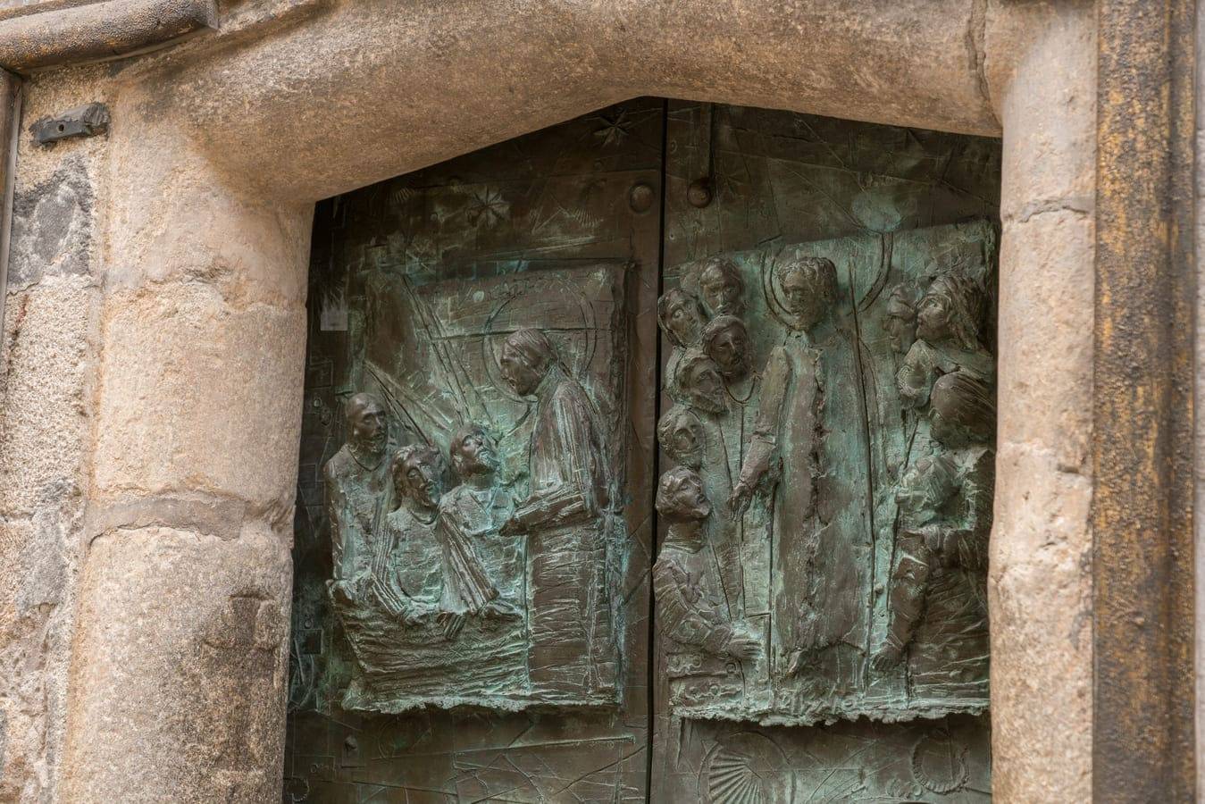 Detalle de algunos relieves de la Puerta Santa de 2004. La Vocación de Santiago y Cristo predicando a sus discípulos