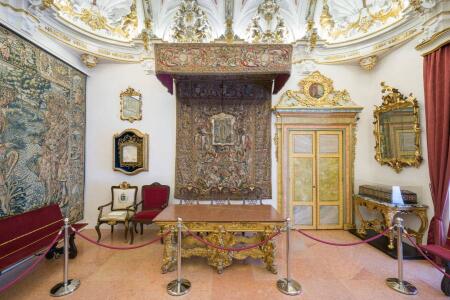 La sala capitular la preside una importante mesa bajo el dosel del dormitorio de Carlos III. A un lado, sillón usado por Juan Pablo II. Al otro caja de taracea para votaciones.