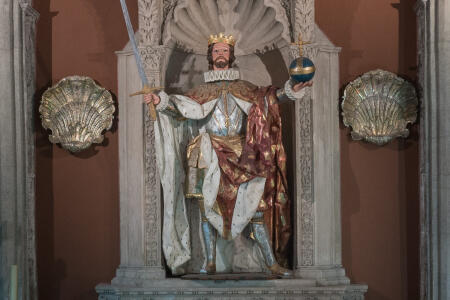 La escultura barroca de San Fernando, vestida con angulosos ropajes y contemplando el cielo.