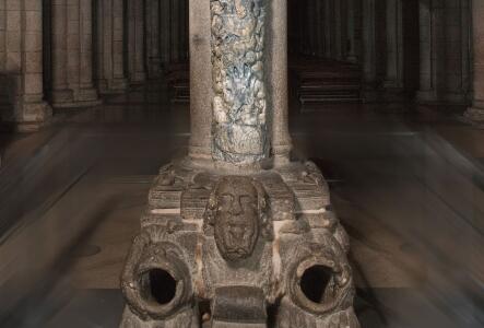 Parte interior del Parteluz del Pórtico de la Gloria. Basamento en el que se representa una figura barbada a horcajadas sobre dos leones, a los que abre las fauces.