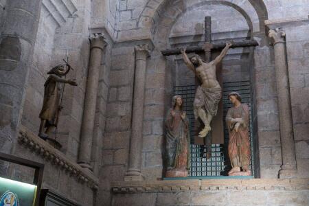 Detalle de calvario gótico de escuela castellana que preside el baptisterio. Al lado, un San Juan Bautista de bronce fundido en los últimos años.