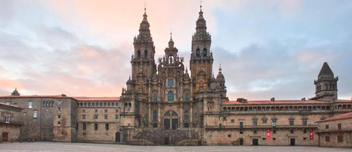 La fachada del Obradoiro desde la plaza homónima. A ambos lados, el Palacio de Gelmírez y el edificio que cierra el claustro y que alberga hoy el Museo de la Catedral.